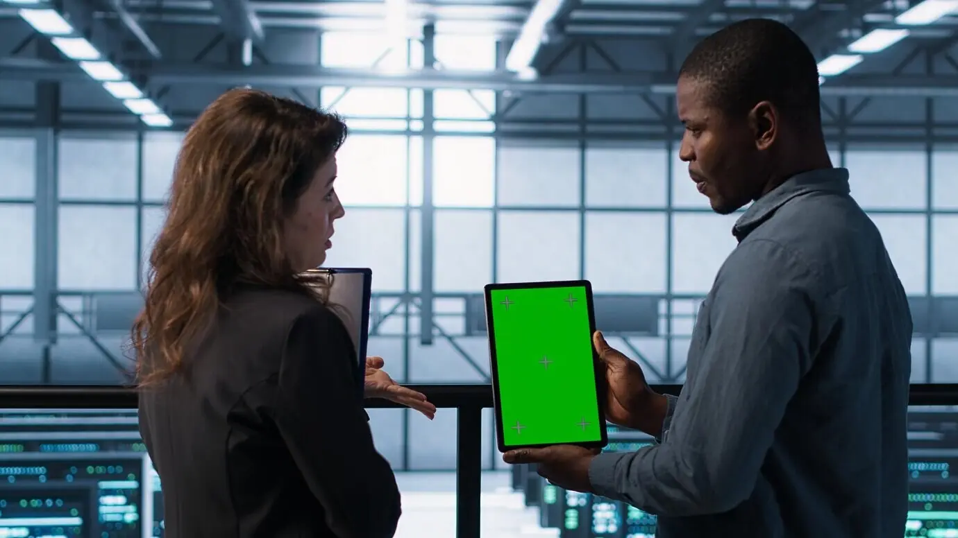 Entwickler im Rechenzentrum nutzen ein Mockup-Tablet, um Performance-Analysen zu beobachten.