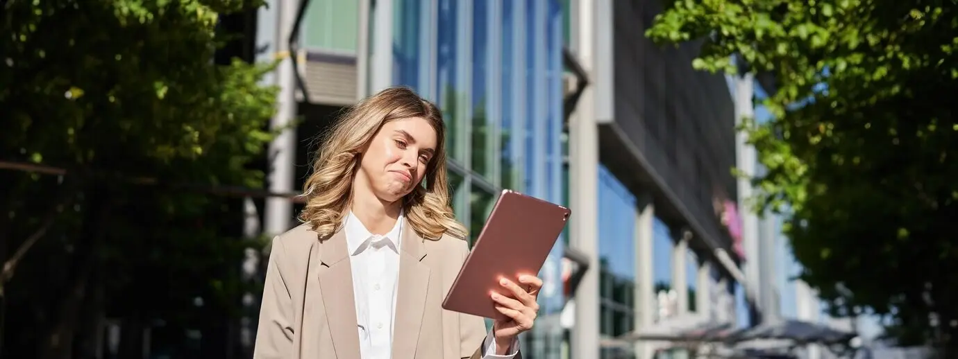Auf dem Weg ins Büro prüft eine erfolgreiche Geschäftsfrau auf der Straße digital ihr Arbeitsprojekt.